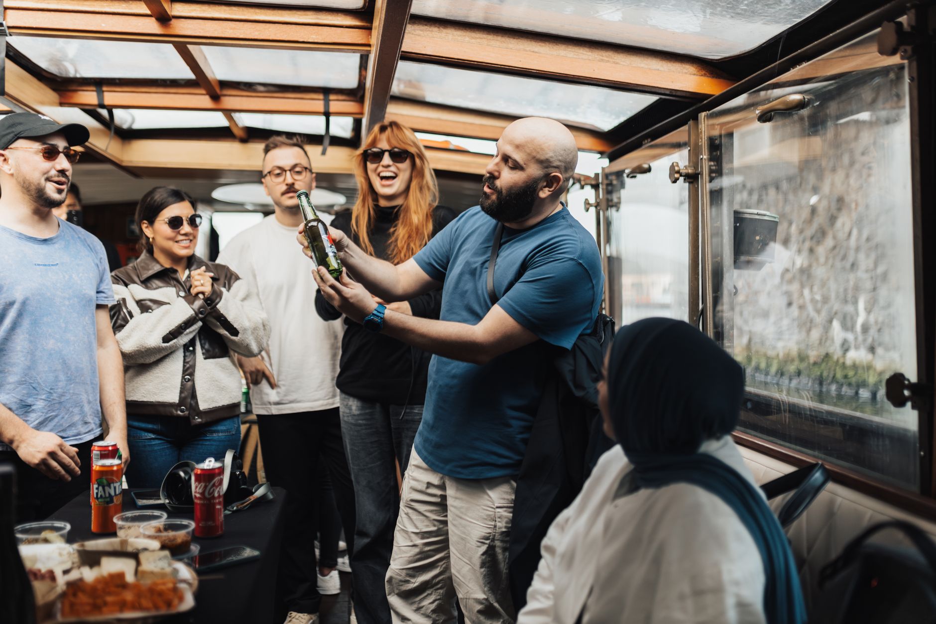 Friends enjoying a casual get-together on a boat, sharing drinks and snacks.