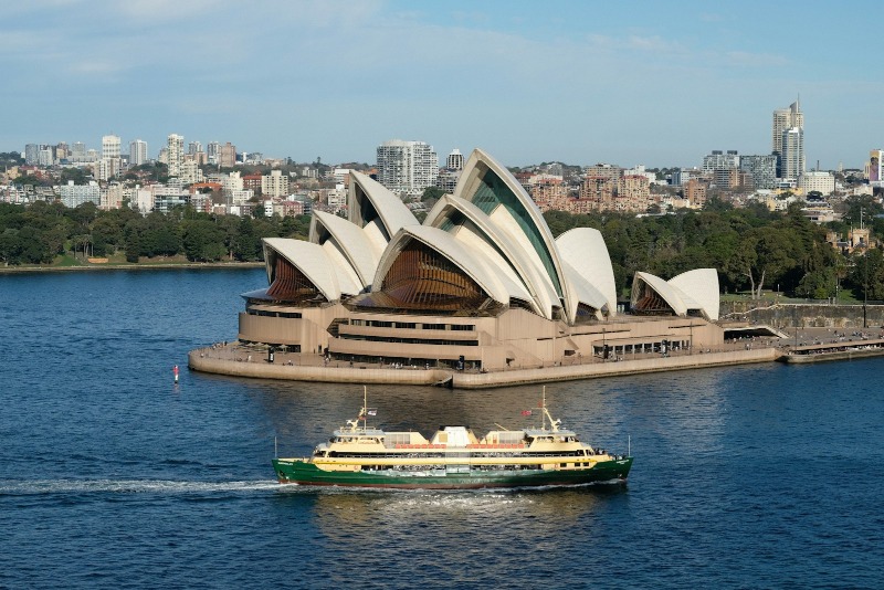 A boat in a body of water near a large building