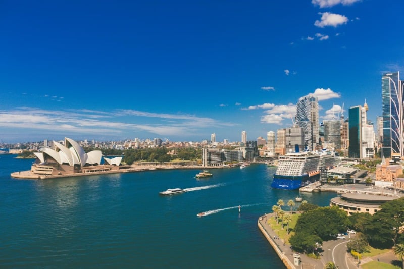 A stunning aerial view of Sydney Opera House and Harbour including city skyline and vibrant water.